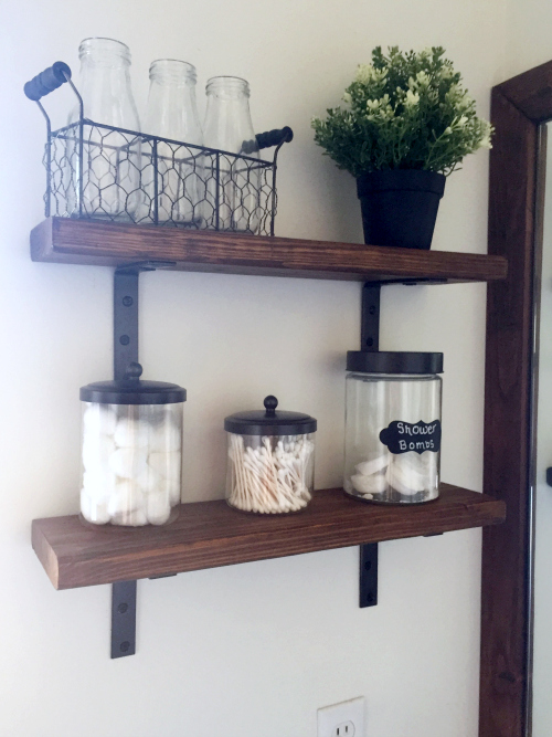 DIY open shelving using barn wood and spray painted corner braces as brackets.