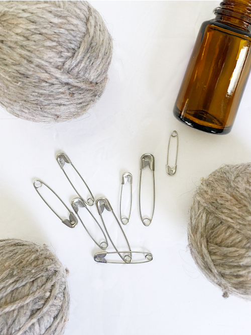 What you need to create a dryer sheet alternative: dryer balls, safety pins, and essential oil (optional)