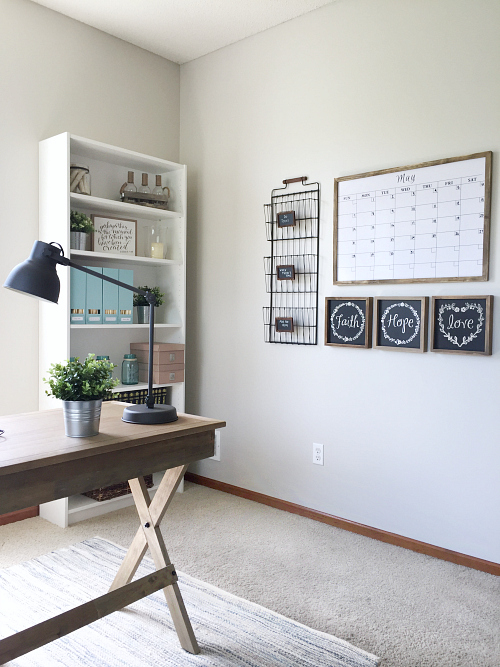 Farmhouse office makeover with view of a command center featuring a white board calendar, paper sorter, and wall decor