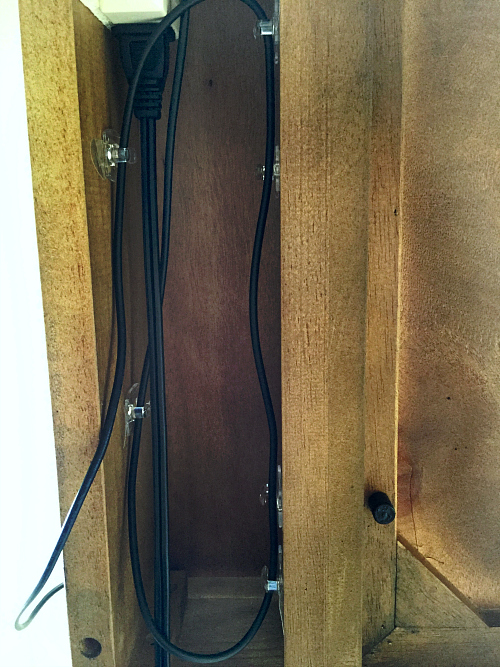 Small command hooks on underside of desk used to hide computer cords