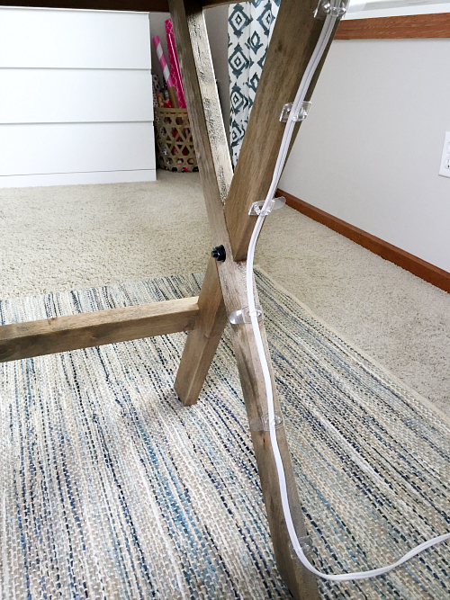 Small command hooks attached to the leg of a desk in order to hide office cords from view