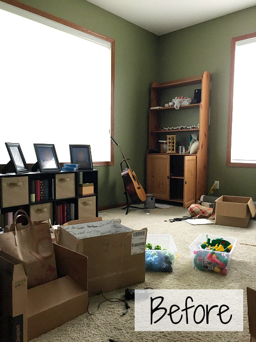 Office prior to makeover showing storage cubbies under window and a wood hutch against the green wall