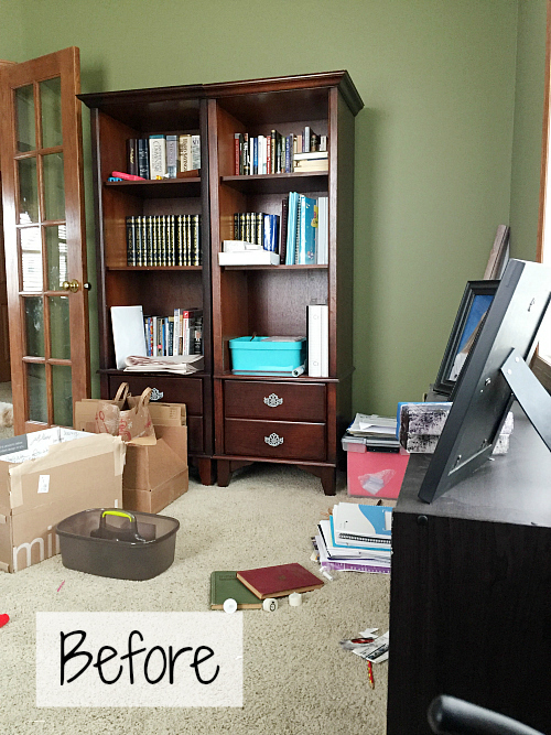 Office before makeover showing cherry bookshelves and paper piles and cardboard boxes scattered on the floor