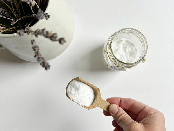 Scoop of baking soda in small wooden scoop