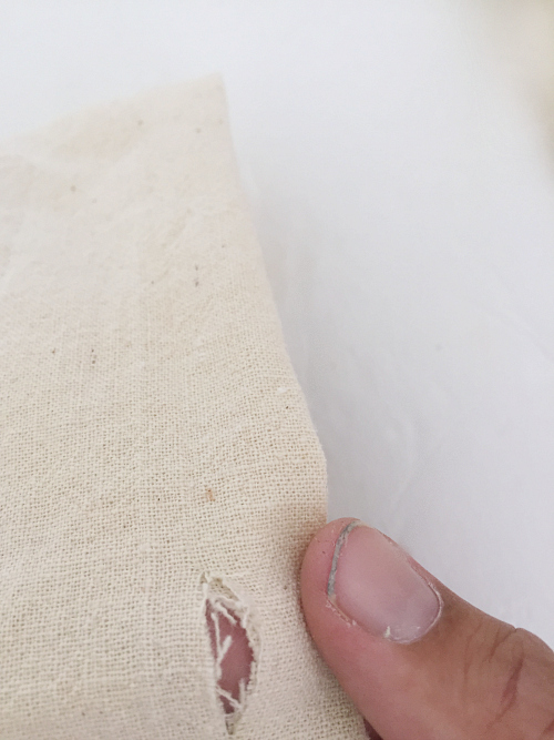 Small hole cut in DIY pillow cover for fabric strips to create closure