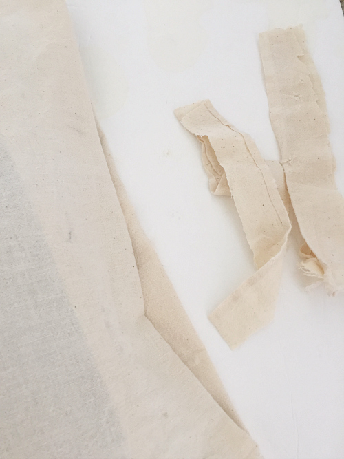 Fabric strips cut from vintage flour sacks to be used as DIY Pillow Closure