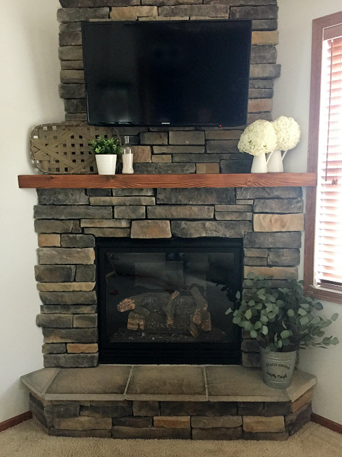 Stone fireplace with faux wood mantel overlay