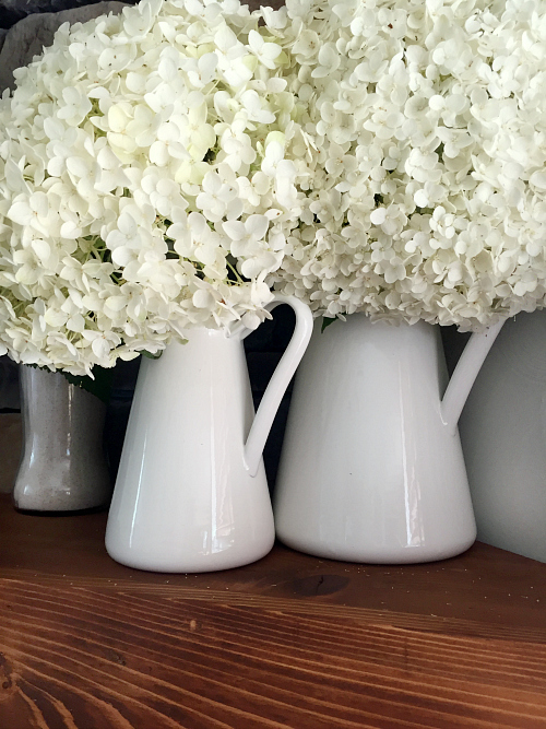 Hydrangeas in pitchers on fireplace mantel 