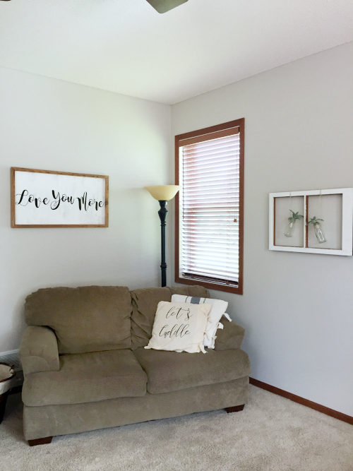 $80 Living Room Makeover done for the $100 Room Challenge showing couch with DIY pillow covers, and a homemade farmhouse style sign on the wall