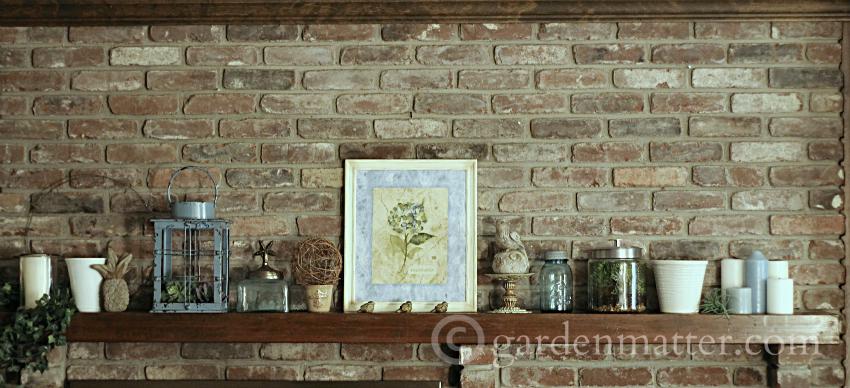 Summery fireplace mantel featuring cream colored pots and glass jars