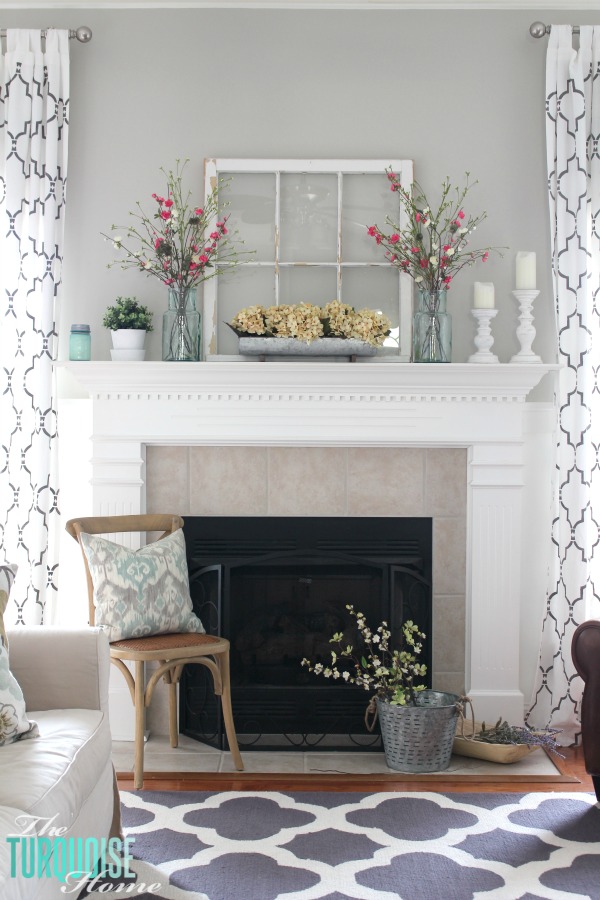 Summer mantel featuring an old window and blue vases filled with pink flowers