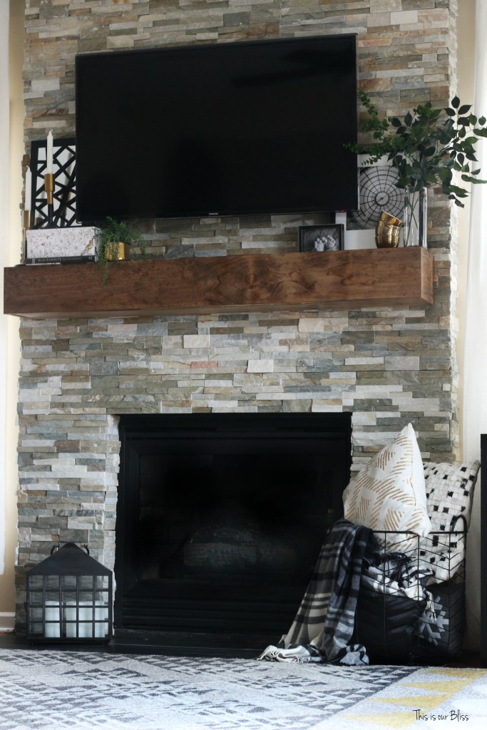 Fireplace mantel adding black accents to help blend with the television