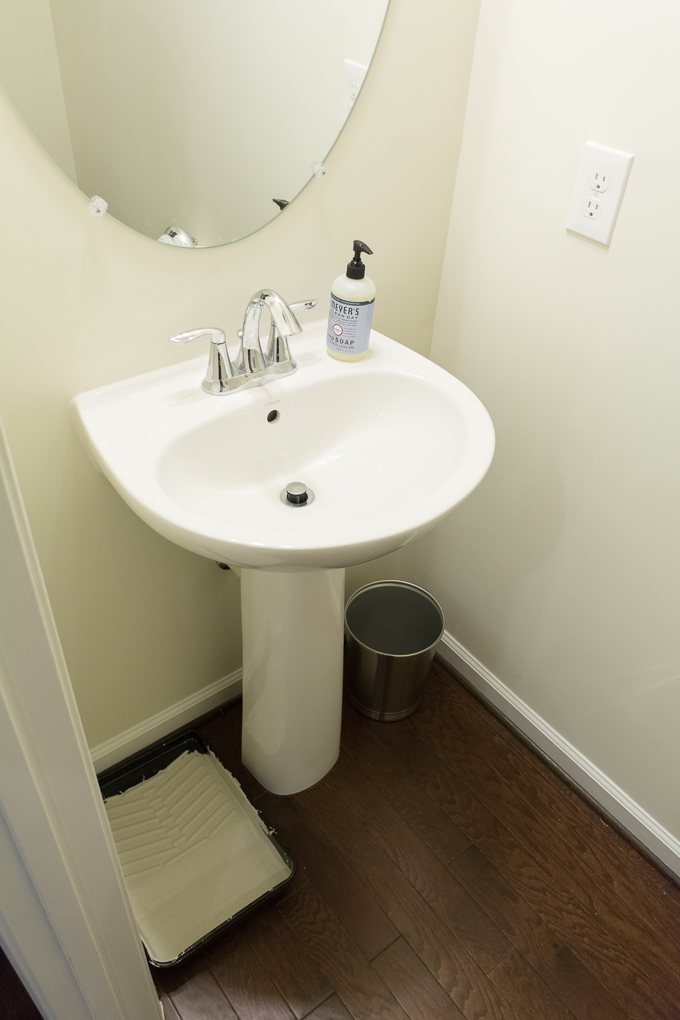 Plain powder room with white walls and a white pedestal sink