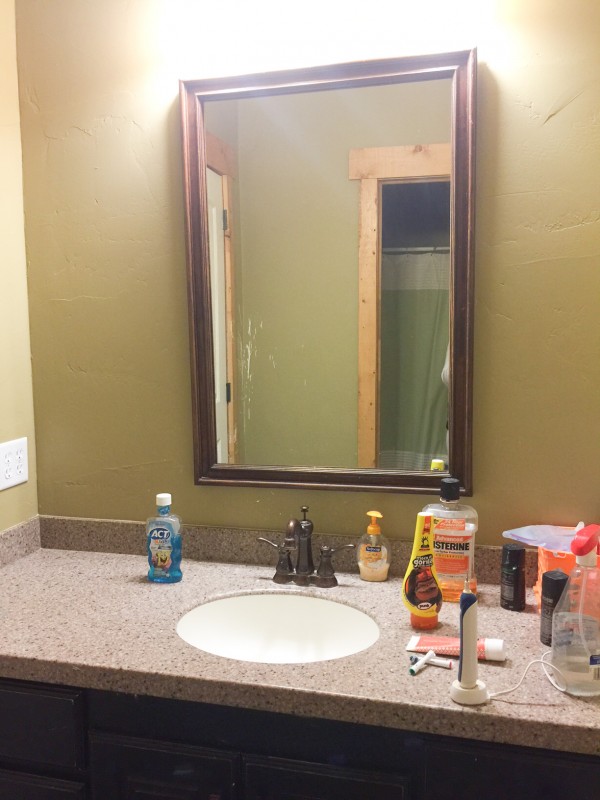 Bathroom shown prior to $100 makeover. Shows dark walls with a dark vanity