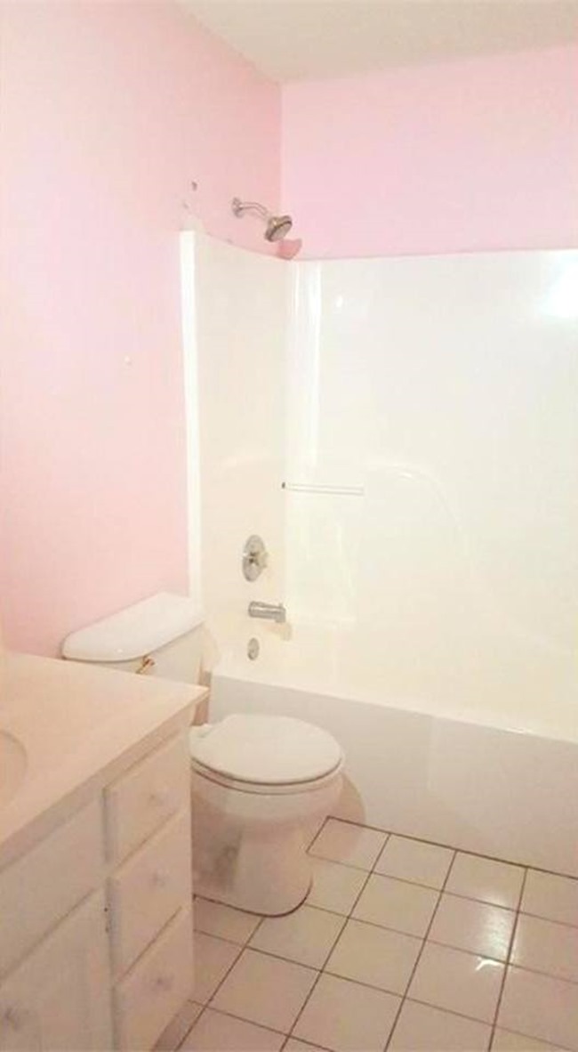 Bathroom with pink walls and a white shower area