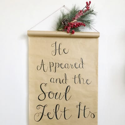DIY Christmas Scroll made from kraft paper topped with faux greenery