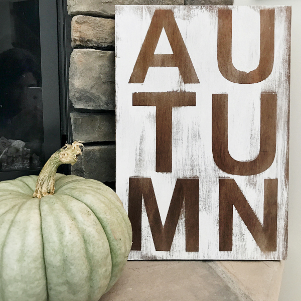 Reversible sign with the word Autumn next to a pumpkin