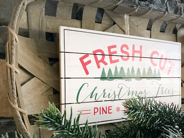 Tobacco basket with Christmas sign used as decor on fireplace mantel