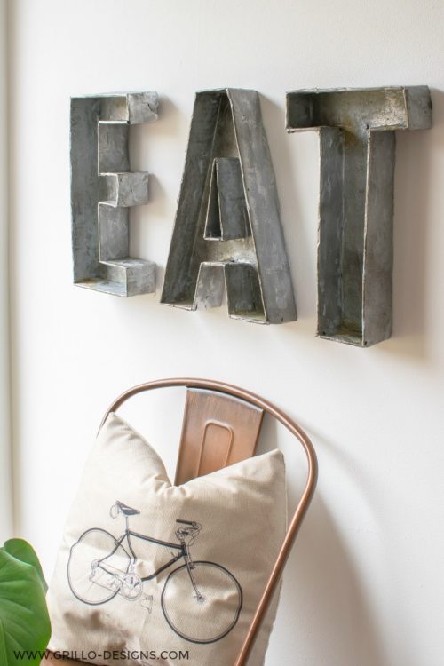 Cardboard boxes used to create faux metal letters in the kitchen