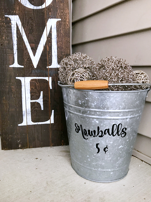 Galvanized metal bucket filled with whimsical snowballs made of wire