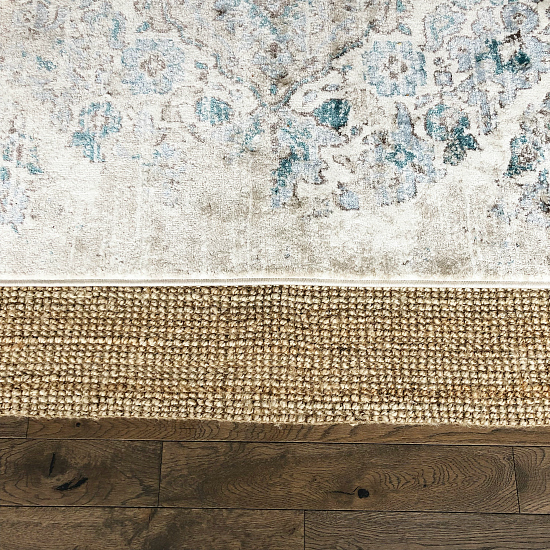 Distressed farmhouse style rug layered with a jute rug in the dining room