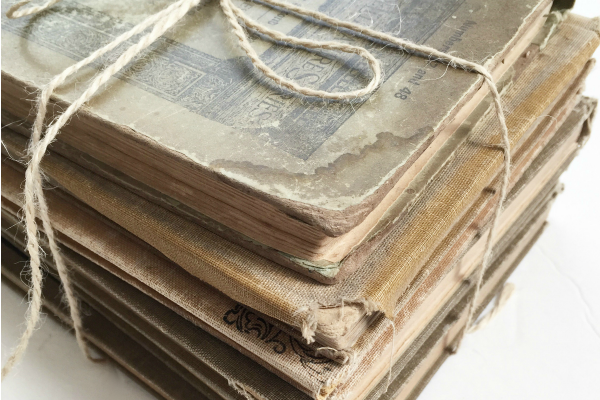 Stack of vintage readers tied with twine and used as decor on an entry table