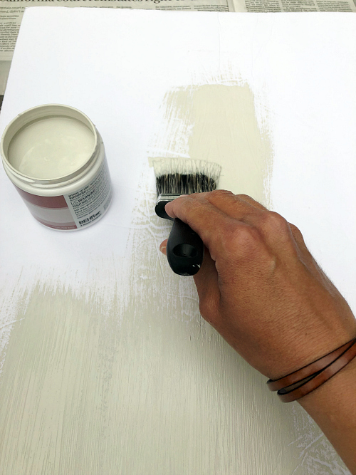 Painting a piece of white foam board to help with choosing paint color for the wall