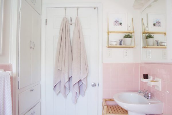 Bathroom after $100 room makeover. Showing freshly painted walls and a new hanging shelf