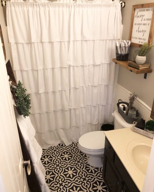 Bathroom after $100 makeover. Includes a painted vanity, stenciled floor, and new white ruffled shower curtain