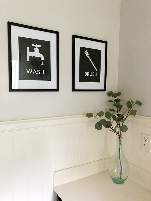 DIY Wall Decor created for a classic farmhouse bathroom using black matted frames with words and images reflecting 