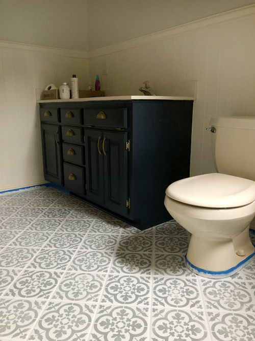 Navy vanity with newly stenciled white and gray tile floor