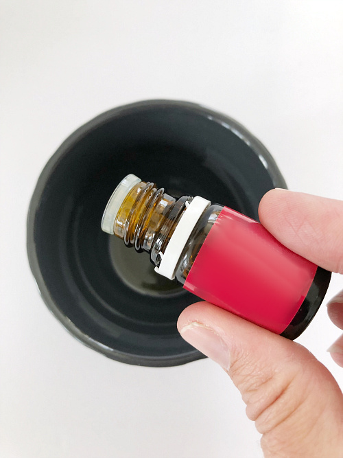 Adding essential oil to olive oil to scent wood ornament