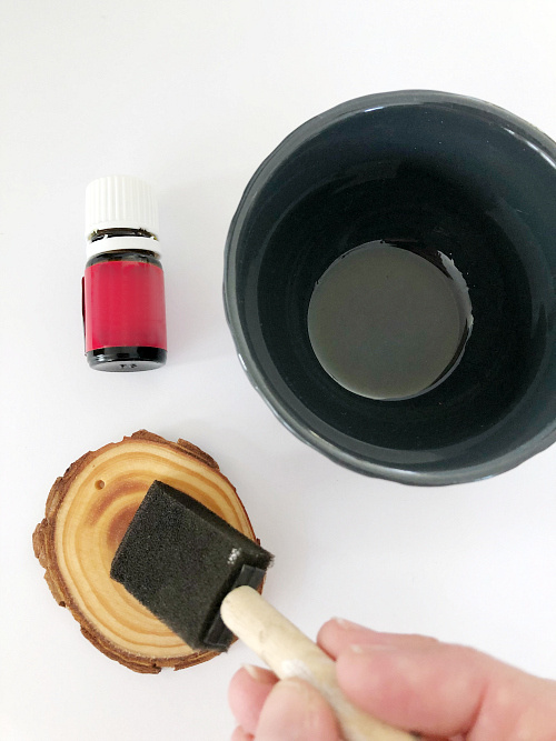 Applying oil mix to scent wood slice ornament