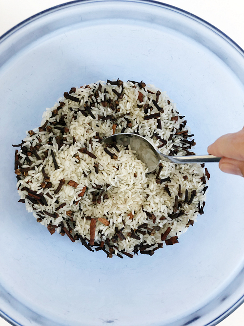 Dried white rice mixed with crushed cinnamon sticks and whole cloves that will be used as the filling for DIY scented coasters