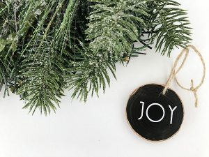DIY Scented wood ornament next to pine garland