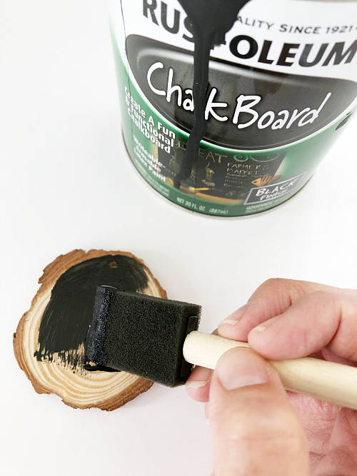 Applying chalkboard paint to wood slice ornament