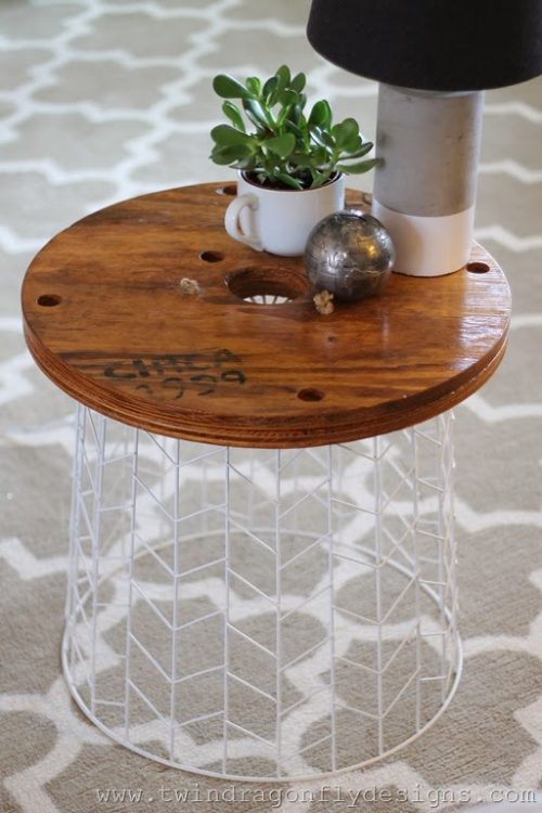 White wire laundry basket turned upside down to be used as a nightstand or table