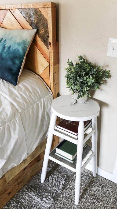 White wooden stool being used as a nightstand