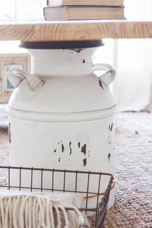 Old rustic milk can being used as the base of a coffee table