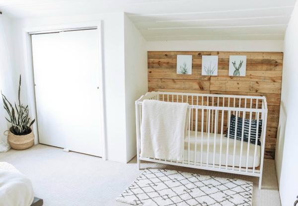 $100 Nursery Makeover featuring a wood paneled wall in a crisp white room