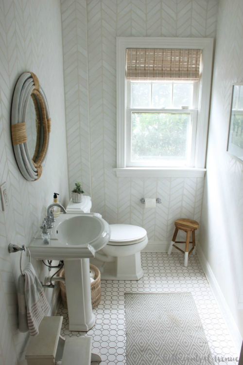 $100 Powder Room Makeover featuring herringbone stenciled walls, a new DIY mirror, and small paint dipped wooden stool