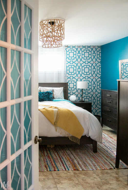 $100 Bedroom Makeover featuring a bright blue stenciled wall and a completely new layout of the room