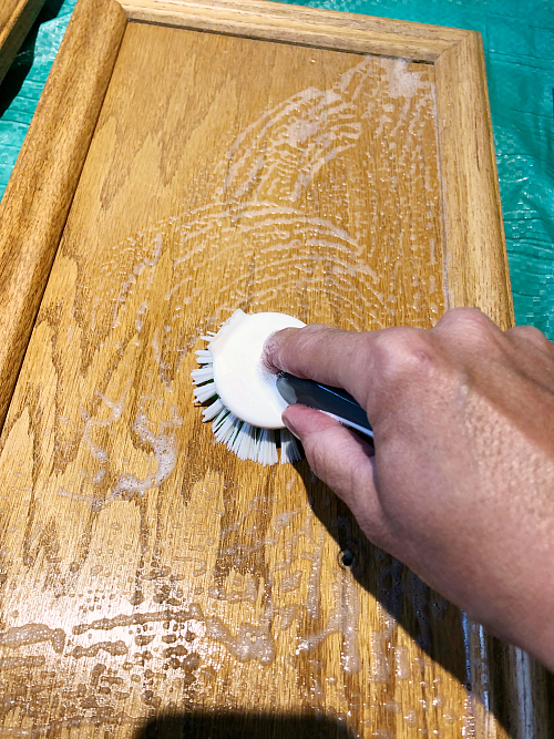 Cleaning cabinet door to prep for hiding wood grain