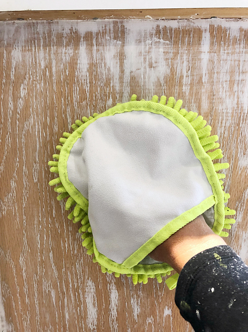 Dusting cabinet with microfiber glove after sanding