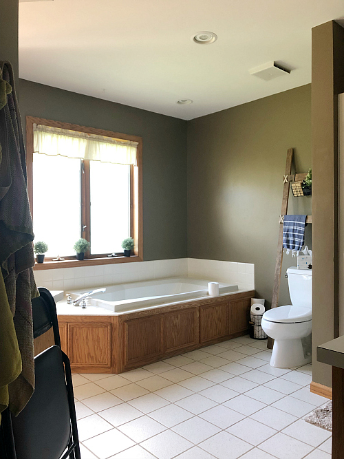 Bathroom showing white tiled floor prior to painting and stenciling
