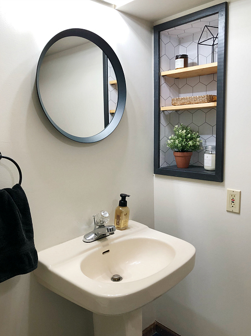 Updated Cubby with removable wallpaper and new wood shelving and new black rimmed round mirror