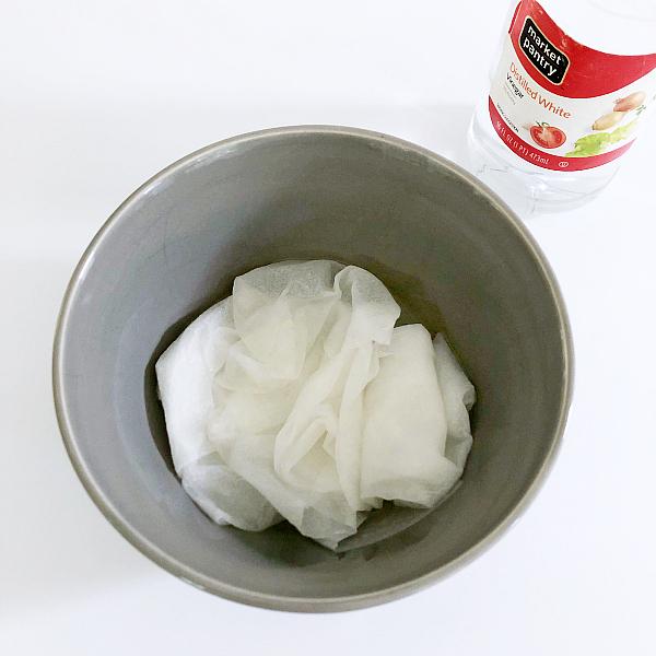 Soaking Paper Towels in Bowl of Vinegar to Clean Shower Head