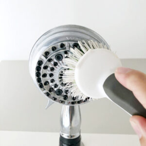 Scrubbing shower head with cleaning brush