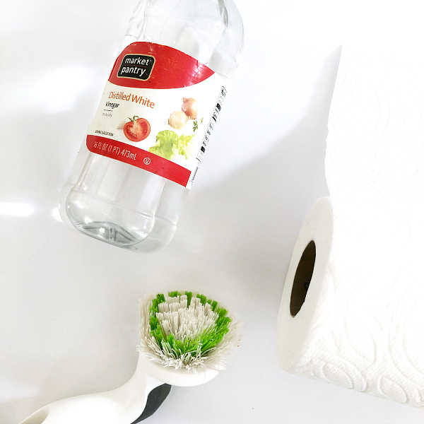 Paper Towels, Vinegar, and Scrub Brush used to clean shower head