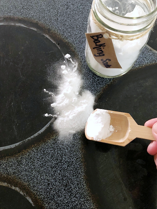 Applying baking soda to glass stove top for cleaning